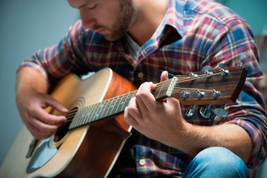 Akustik gitar çalan müzisyen.
