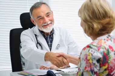Doktor hastaya el sallayarak