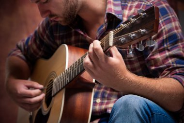 Akustik gitar çalan müzisyen.