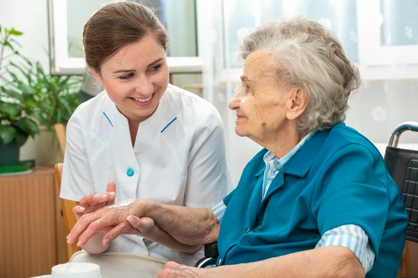 La femme âgée est assistée par une infirmière à domicile — Photo