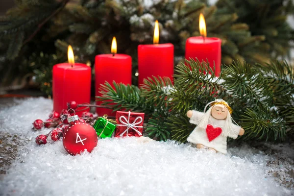 Velas vermelhas queimando na neve para o quarto advento — Fotografia de Stock