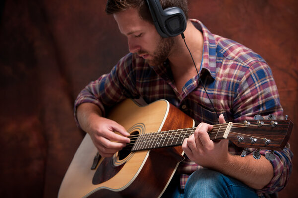 musician playing acoustic guitar