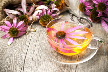 Cup of echinacea  tea on wooden table clipart