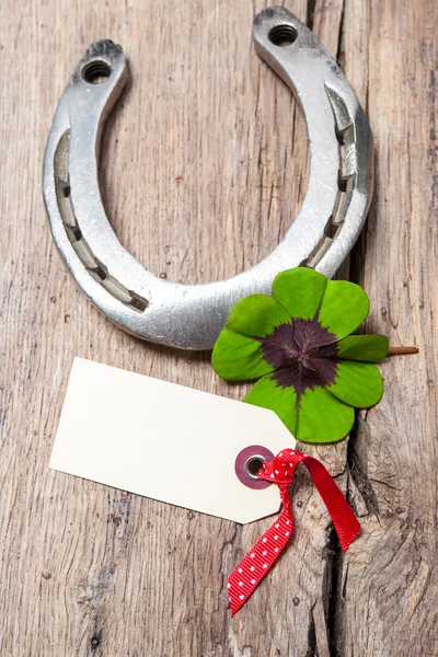 Horseshoe and four leaf clover with empty tag — Stock Photo, Image