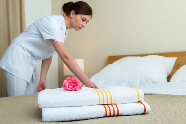 Maid making bed in hotel room — Stock Photo, Image