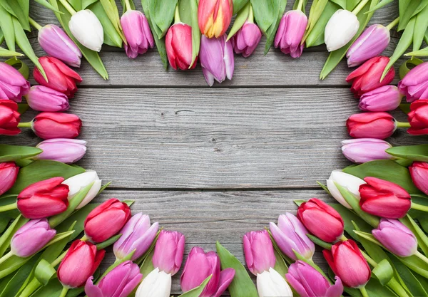 Tulpen gerangschikt op oude houten achtergrond — Stockfoto