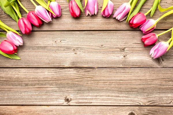 Tulipas dispostas em fundo de madeira velha — Fotografia de Stock