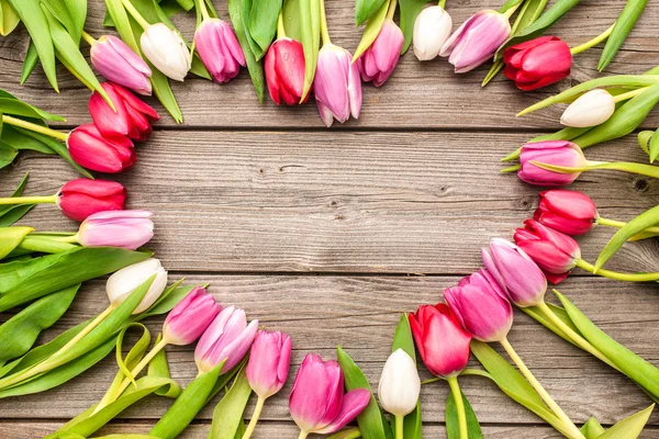 Tulpen gerangschikt op oude houten achtergrond — Stockfoto