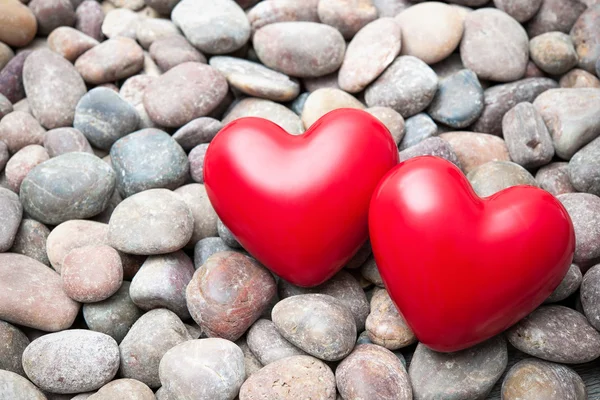 Zwei rote Herzen auf Kieseln — Stockfoto