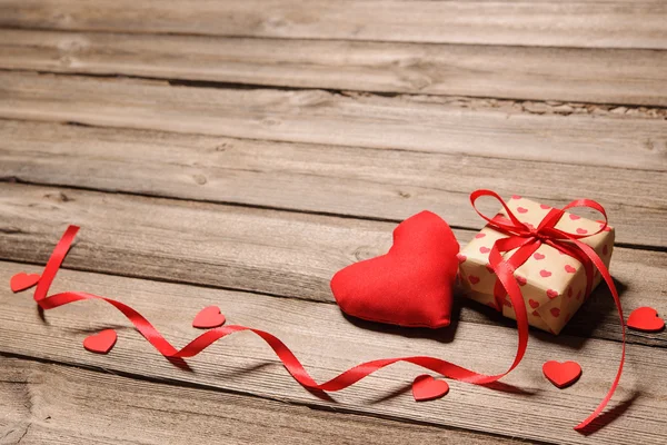 Corazón y caja de regalo con cinta roja — Foto de Stock