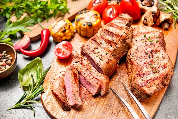 Filetes de ternera a la parrilla en la tabla de cortar —  Fotos de Stock