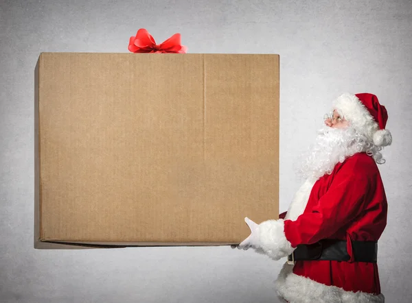 Санта-Клаус держит большую подарочную коробку — стоковое фото