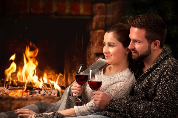 Couple relaxing with glass of wine at fireplace — Stock Photo, Image