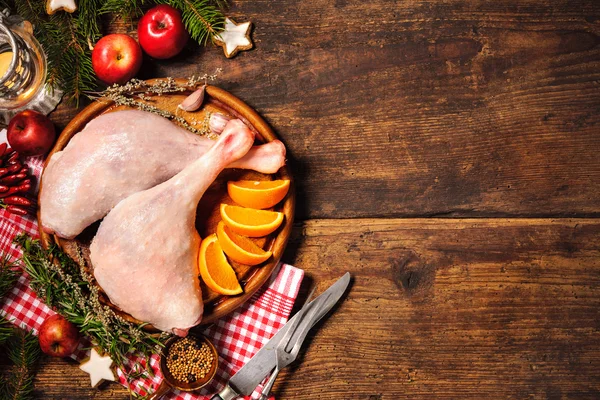 Raw goose legs with herbs on cutting board — Stock Photo, Image