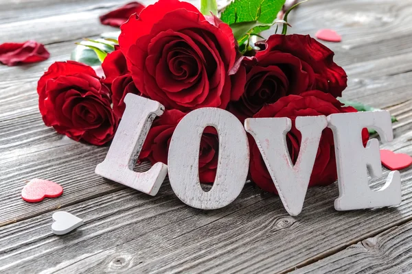 Rosas vermelhas flores e palavra amor — Fotografia de Stock
