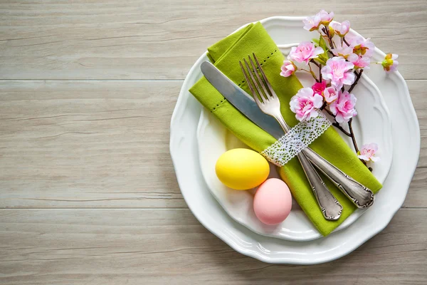 Накрытие пасхального стола с весенними цветами и столовыми приборами — стоковое фото