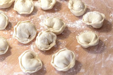 Ahşap masadaki pişmemiş Rus Pelmeni Ev yapımı Pelmeni Ravioli veya Hamur köftesi .