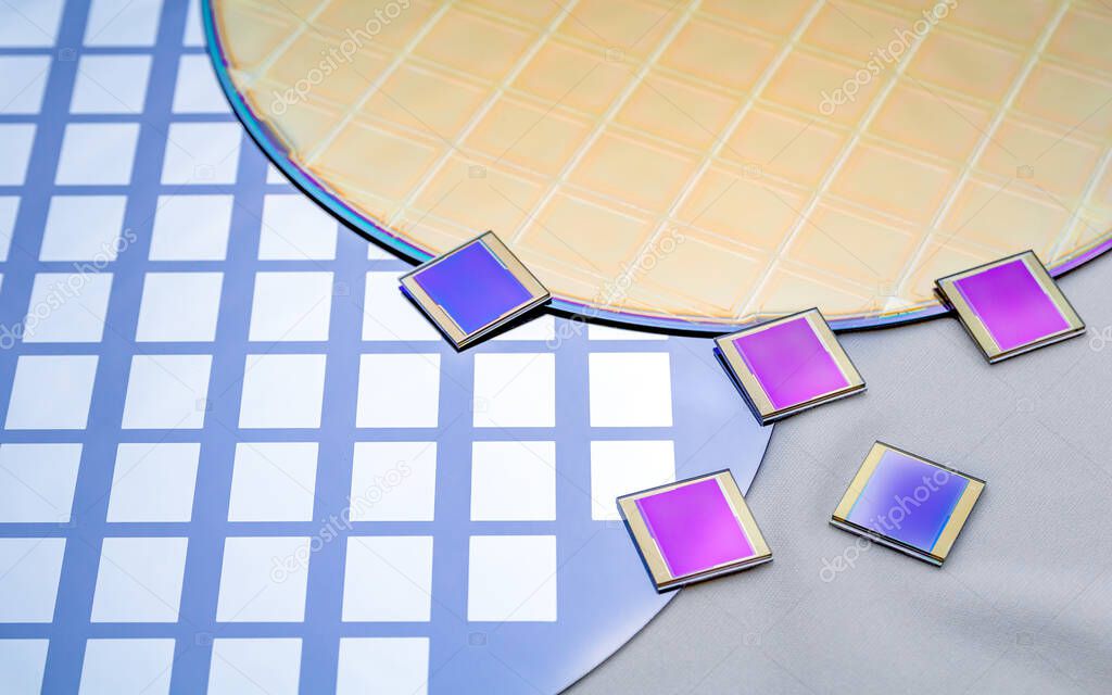 Several silicon wafers with printed circuit and separate microchips.