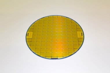 Silicon Wafer with microchip yellow color, backside is grey color - A wafer is a thin slice of semiconductor material, such as a crystalline silicon, .Wafer with microchips.Rainbow on silicon wafer.Color silicon wafers with glare. clipart