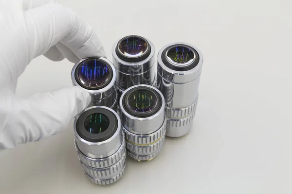 Detalle de la lente del microscopio sobre fondo blanco.Acercamiento de los objetivos del microscopio. —  Fotos de Stock