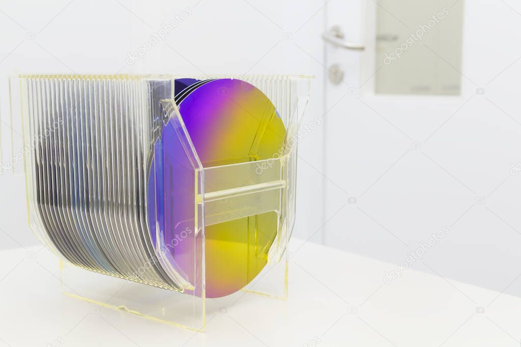 Silicon Wafers in plastic storage box in clear room of semiconductor foundry.