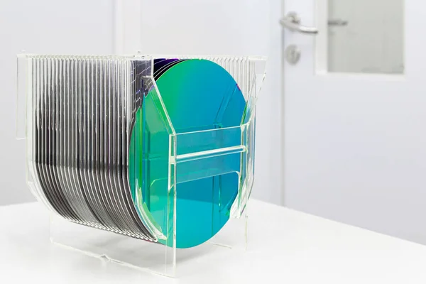 Silicon Wafers in plastic storage box in clear room of semiconductor foundry. Stock Photo