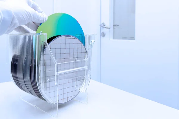 Silicon Wafers in storage box on table in clear room prepared for production of semiconductor foundry. Stock Picture