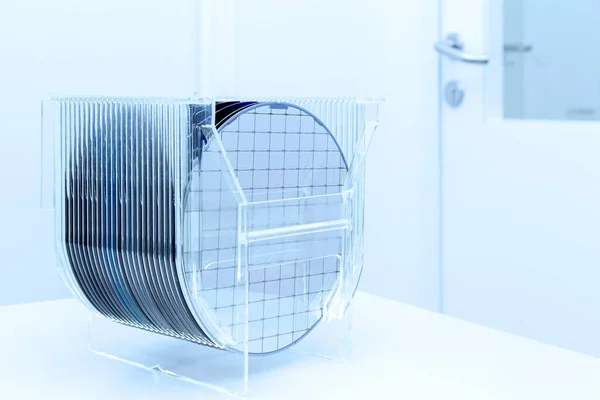 Silicon Wafers in plastic storage box in clear room of semiconductor foundry. Stock Image