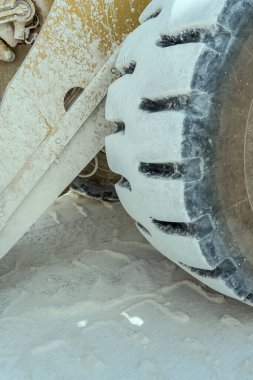 Carrara, Apuane, Tuscany, İtalya yakınlarındaki taş ocağında çekilen büyük dozer lastiğinin üzerindeki beyaz mermer tozunun ayrıntıları.