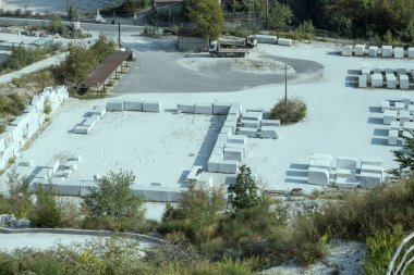 Carrara, Apuane, Tuscany, İtalya yakınlarındaki parlak ışıkta çekilen büyük meydanda hız yapmaya hazır oyulmuş beyaz mermer bloklar.