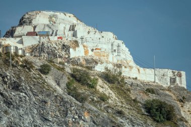 CARRARA, ITALY - Eylül 19 2020: Dağların tepesindeki mermer ocağındaki uçurumun üzerindeki duvar resmi, 19 Eylül 2020 'de Carrara, Apuane, Toskana, İtalya yakınlarında parlak ışıkta çekildi.