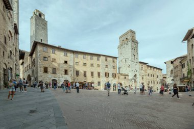SAN GIMIGNANO, ITALY - 20 Eylül 2020: Sarnıç meydanında gezen insanlarla dolu şehir manzarası, 20 Eylül 2020 tarihinde San Gimignano, Siena, Tuscany, İtalya