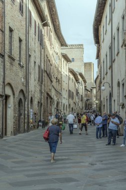 SAN GIMIGNANO, İtalya - 20 Eylül 2020: San Matteo caddesinde gezen insanlarla dolu şehir manzarası, 20 Eylül 2020 tarihinde San Gimignano, Siena, Toskana, İtalya