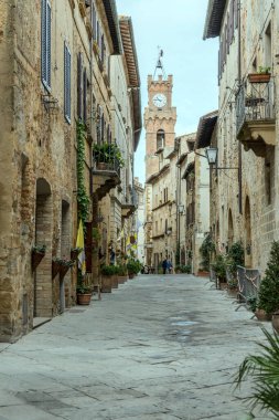 PIENZA, ITALY - 23 Eylül 2020: Tarihi kentin merkez caddesindeki şehir merkezi kulesi, 23 Eylül 2020 'de Pienza, Siena, Tuscany, İtalya' da parlak ışıkta çekildi.