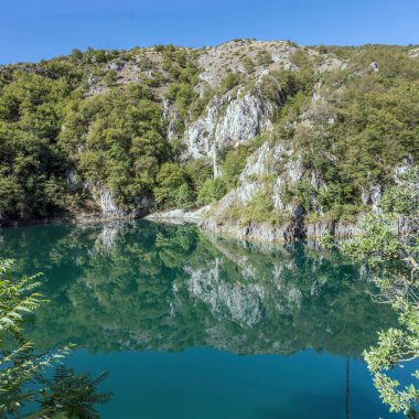 Sagittario nehir geçidinin sert kayalık yamaçları mavi sulara yansıyor, parlak ışıkta S.Domenico, L 'Aquila, Abruzzo, İtalya yakınlarında çekiliyor.