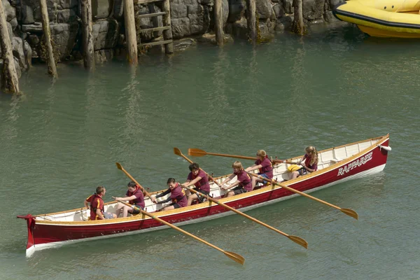 Junges Team auf Ruderboot bei Clovelly, Devon — Stockfoto