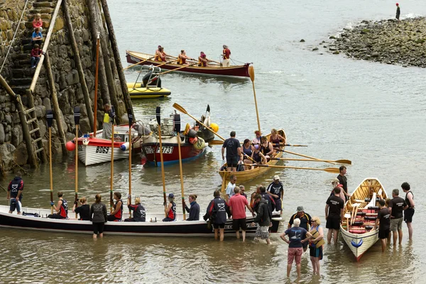 Ruderboote und Teams landen an der Hafeneinfahrt von Clovelly, Devon — Stockfoto