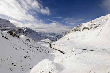 Julier pass road climbing among snow, Switzerland clipart