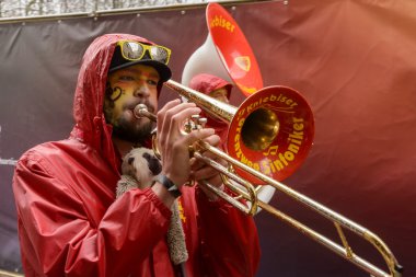 trombone player marching  under rain at Carnival parade, Stuttga