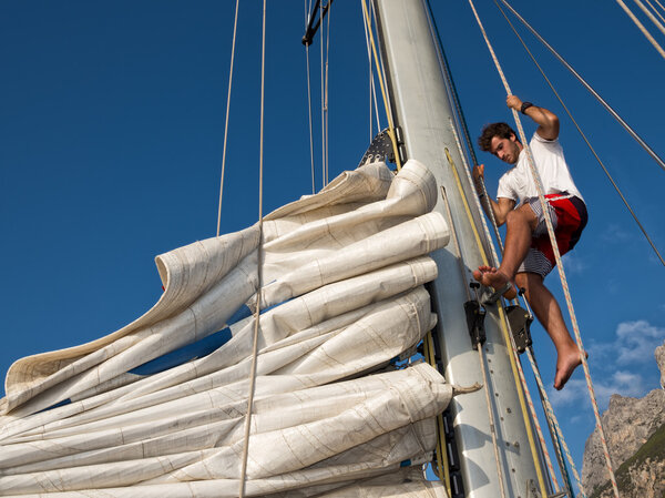 young man working on sailing ship, active lifestyle, summer sport concept