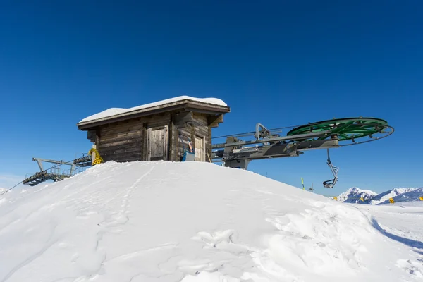 Wooden hut and ski lift in mountain — Stock Photo, Image