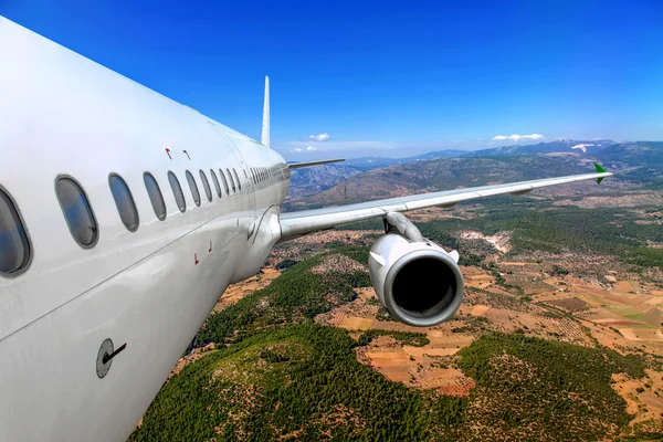 Avião de passageiros voando sobre o solo — Fotografia de Stock