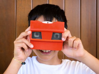 little boy playing with vintage 3d viewer clipart