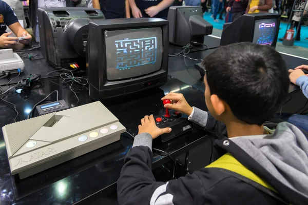 Milan, Italië - 25 oktober: Boy spelen met retro Atari Pac Man op Games Week 2015, evenement gewijd aan video-games en elektronische entertainment op 25 oktober 2015 in Milaan. — Stockfoto