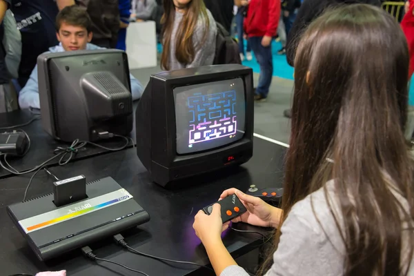 Мілан, Італія — 25 жовтня: Дівчинка, граючи з vintage Atari Pac-Man на ігри тижні 2015 року захід, присвячений відеоігри та електронні розваги на 25 жовтня 2015 року у Мілані. — стокове фото