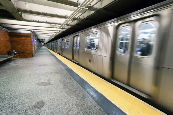 Träna på New Yorks tunnelbana med hemlösa sover på plattformen — Stockfoto