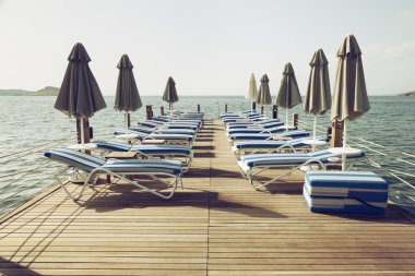 plaj şemsiyesi ve sandalyeler ile Vintage tonda pier
