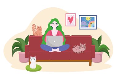 Kadın kanepede dizüstü bilgisayar ve kedilerle çalışıyor.
