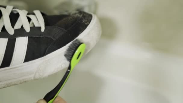 Prendersi cura delle scarpe con la suola bianca con spazzolino e dentifricio al rallentatore — Video Stock