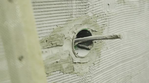 Ingebouwd stopcontact in de muur tijdens renovatie met een uitstekende draad — Stockvideo
